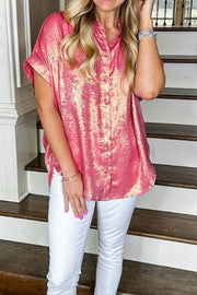 Metallic finish dusty pink oversized button-down blouse with short sleeves.