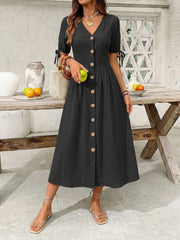 Black button-down midi dress with V-neck, short puff sleeves with tie detail, and A-line skirt.