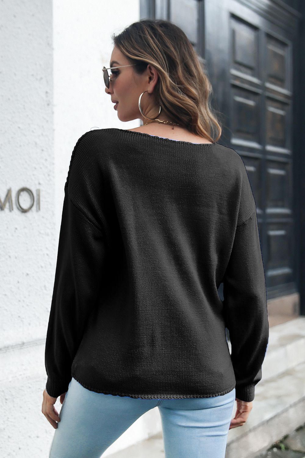 Black acrylic cable knit V-neck pullover sweater with long sleeves and a relaxed fit.