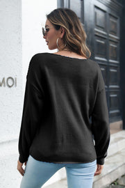 Black acrylic cable knit V-neck pullover sweater with long sleeves and a relaxed fit.