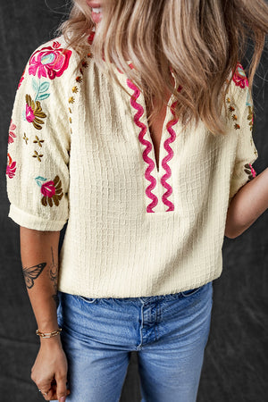 Beige embroidered blouse with voluminous sleeves and pink neckline detail