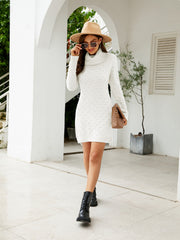White textured turtleneck sweater dress with pearl-like dots and long sleeves.