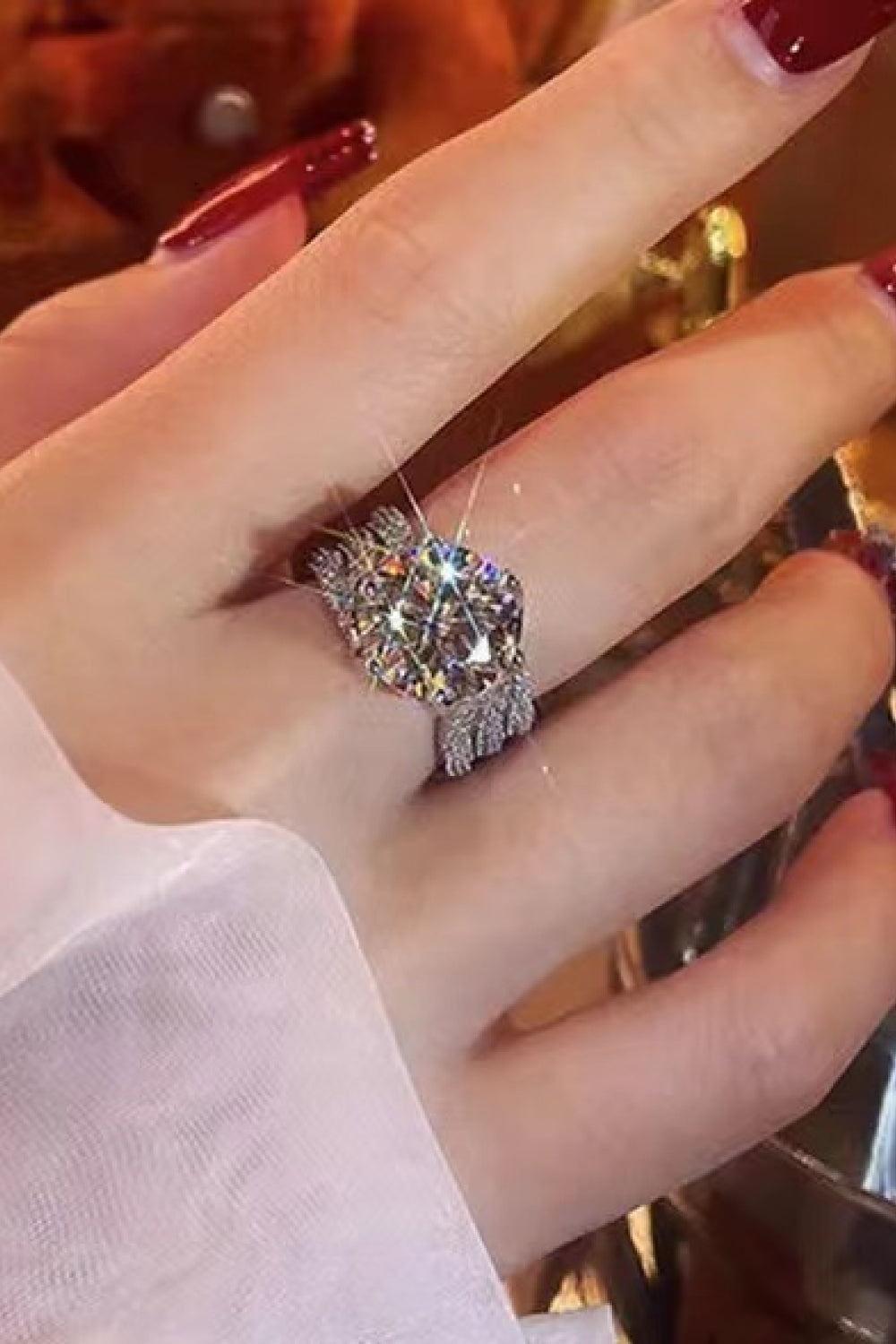 Silver pavé halo moissanite engagement ring with a large center stone.