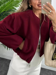 Burgundy zip up cropped bomber jacket with pockets and a round neckline.