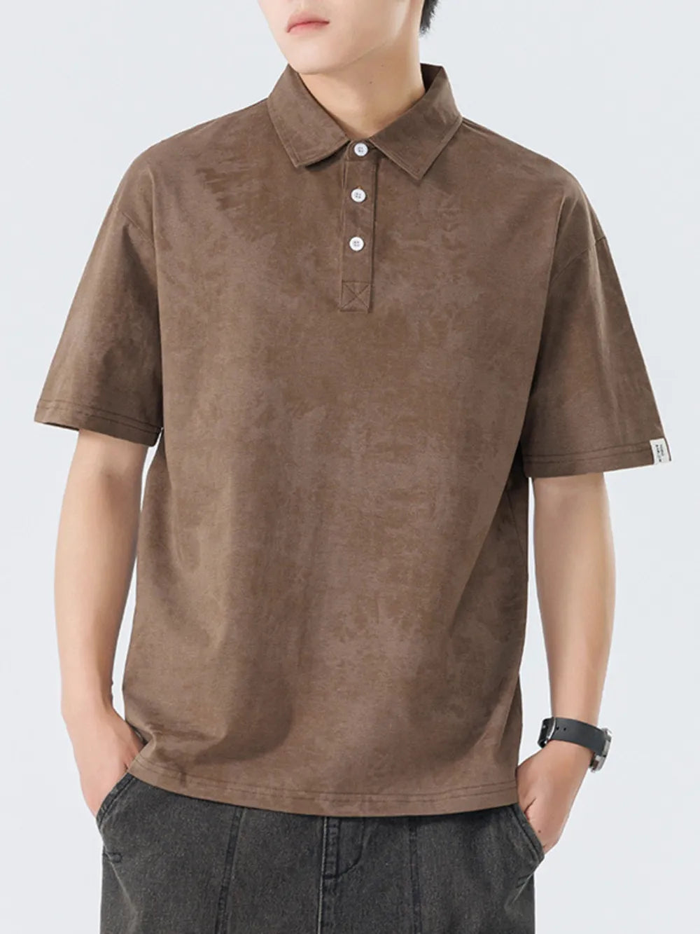 Brown cotton polo shirt with subtle texture and buttoned placket.