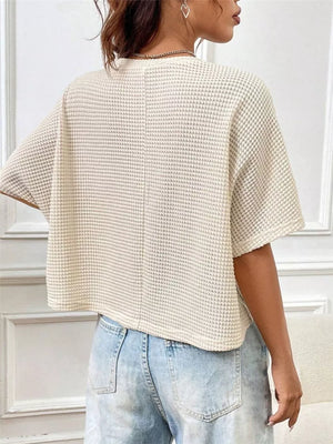 Apricot waffle-knit cropped t-shirt with crew neck and short sleeves.