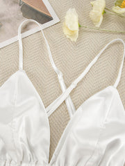 White satin bralette with criss-cross adjustable straps and lace trim detail.