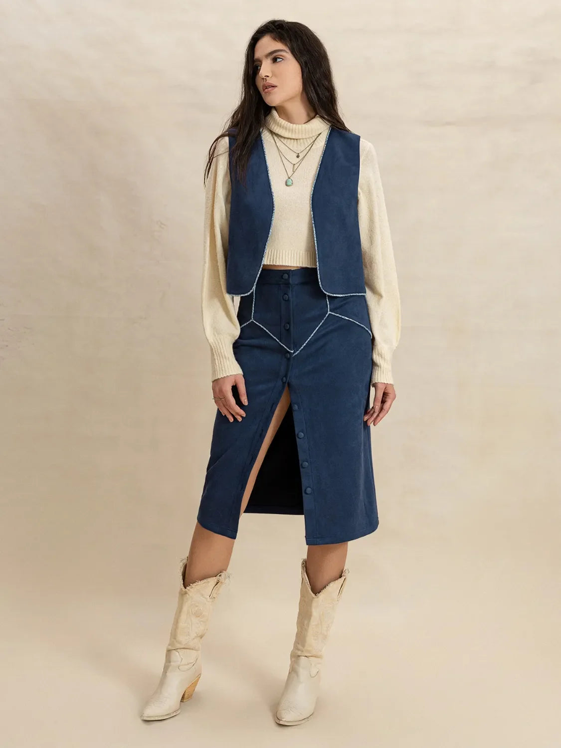 Peacock blue suede vest and button-front skirt set with contrast stitching.