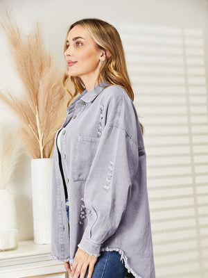 Distressed denim overshirt with raw hem in lilac, featuring button front and frayed details.