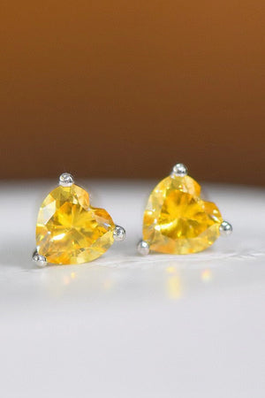 Yellow heart moissanite stud earrings with silver prong settings.