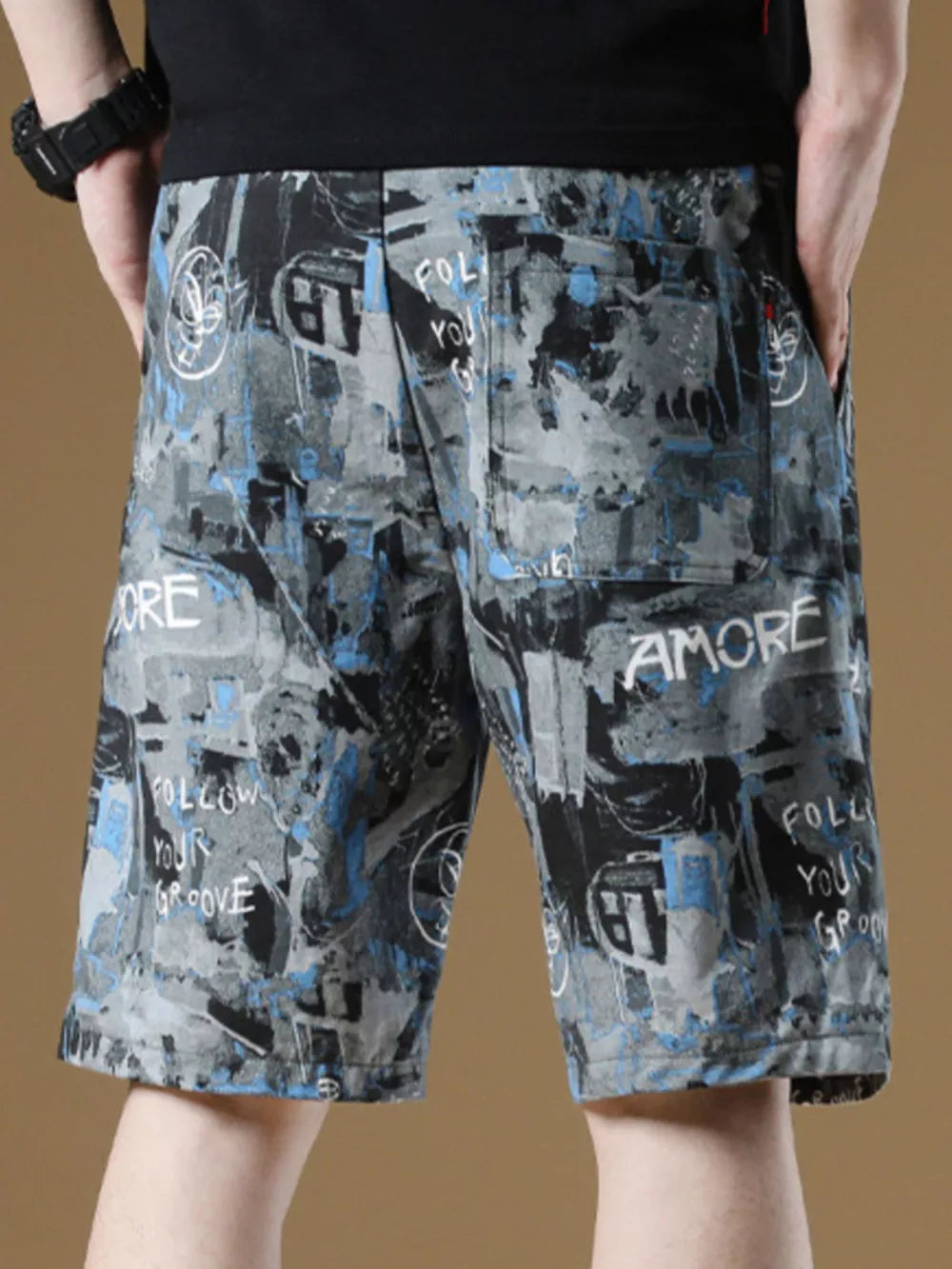 Casual cotton-blend chino shorts with abstract graffiti print and drawstring detail.