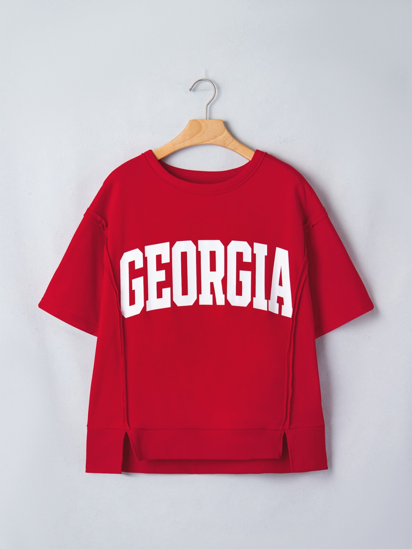 Red cotton blend tee with white GEORGIA lettering, drop shoulders, and side slits.