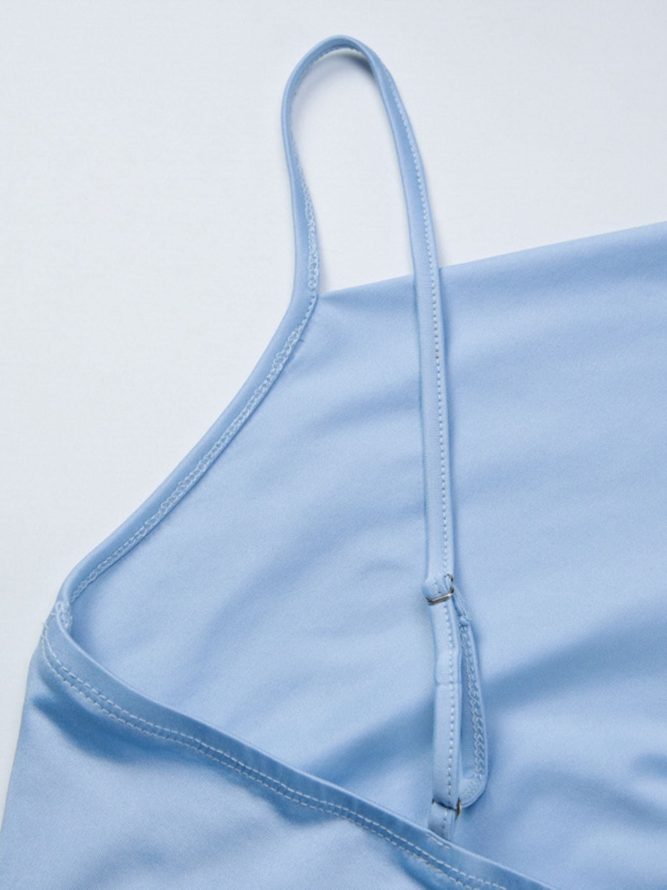 Light blue asymmetrical cami top with adjustable spaghetti straps.