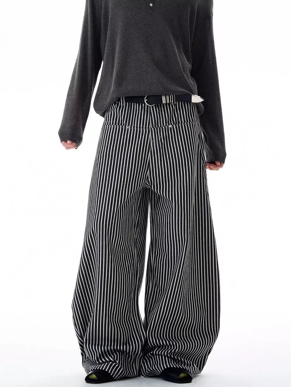 Men's black and white striped wide-leg sweatpants with a belt.