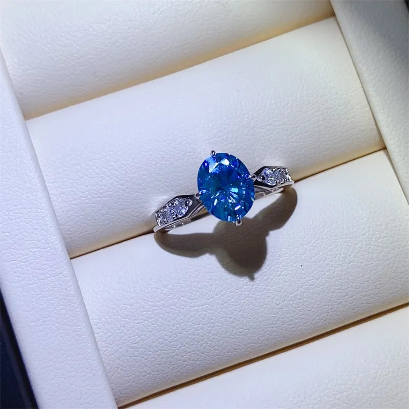 Sterling silver ring with oval blue moissanite and diamond halo accents.