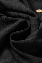 Black textured ribbed button-down shirt with a visible wood-look button.