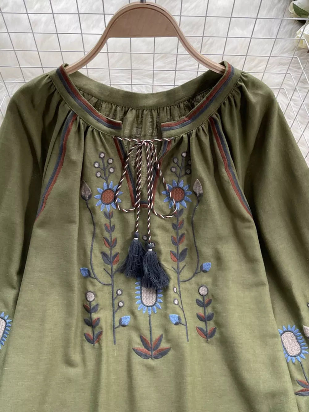Green embroidered tie neck blouse with billowy sleeves and floral detail