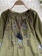 Green embroidered tie neck blouse with billowy sleeves and floral detail