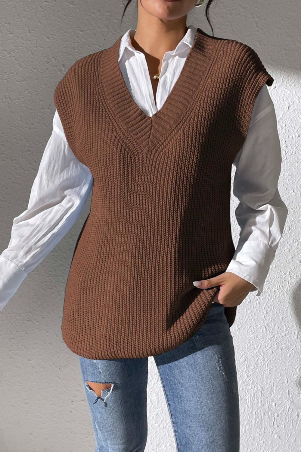 Textured knit V-neck sleeveless top in chocolate acrylic, styled over a white shirt.