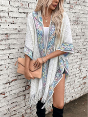 White knit hooded wrap with colorful embroidered trim and fringe detail.