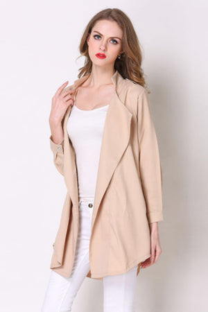 Tan drape-front trench coat with shoulder detailing and buttoned cuffs.