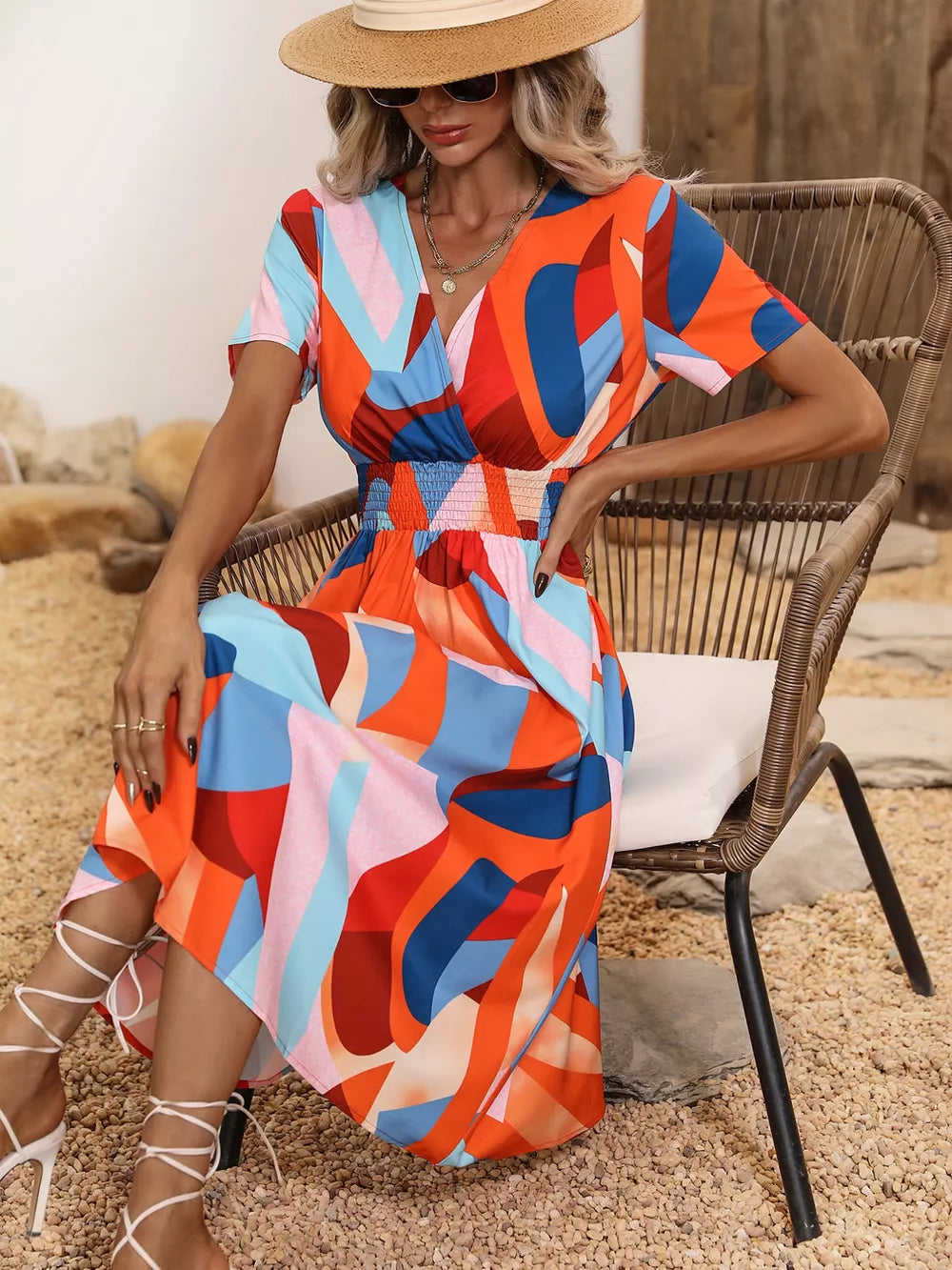 Vibrant leaf pattern midi dress with a-line cut, v-neck, short sleeves, and smocked waist.
