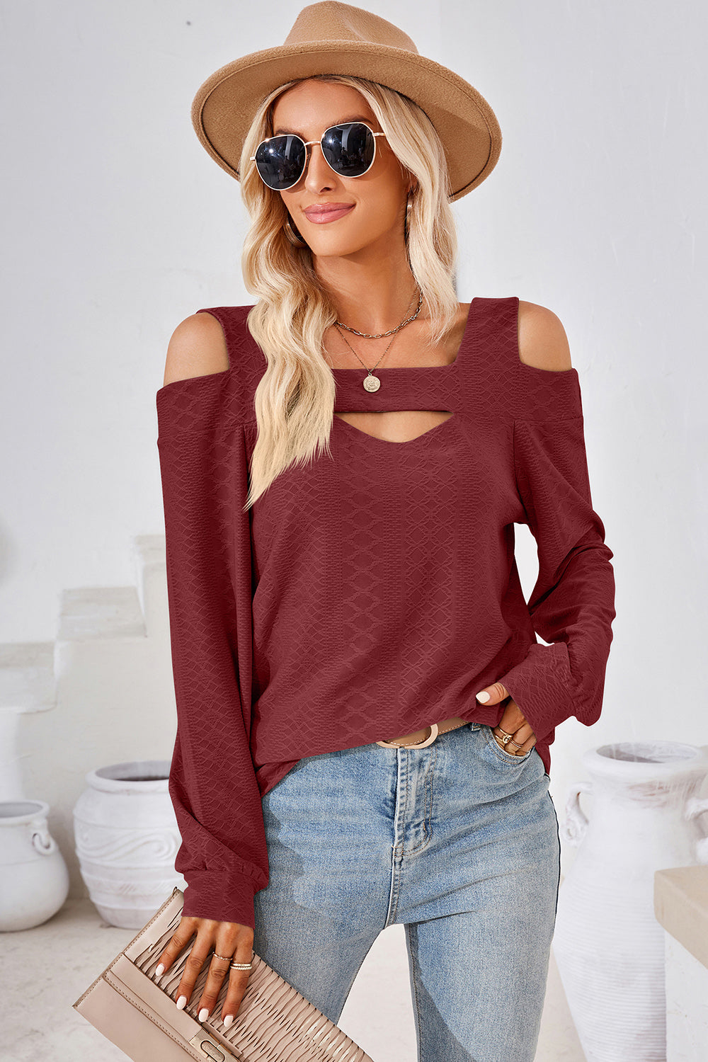 Burgundy geometric cutout shoulder top with long sleeves and a textured pattern.