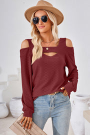 Burgundy geometric cutout shoulder top with long sleeves and a textured pattern.