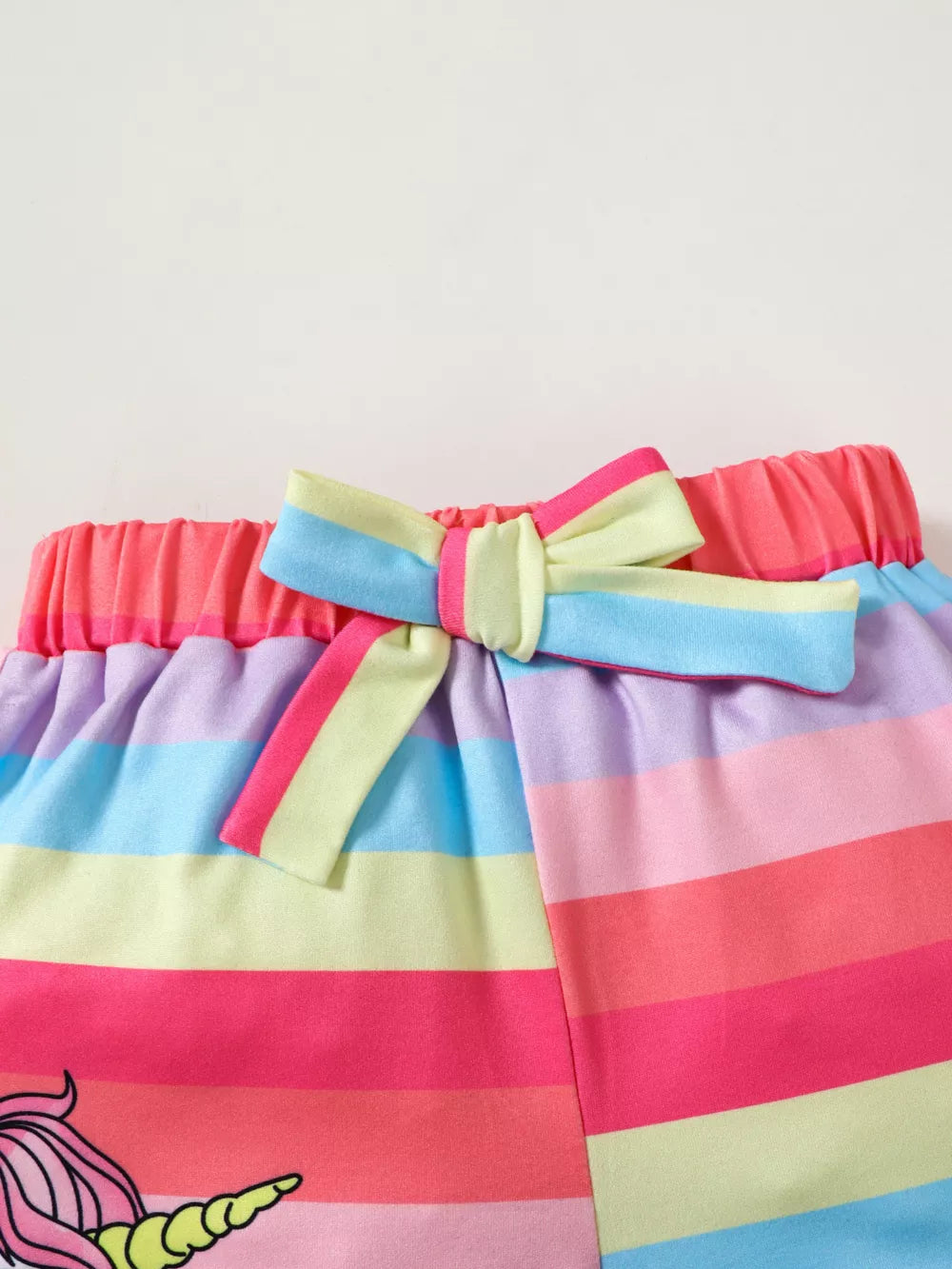 Baby set shorts with rainbow stripes, unicorn graphic, and bow detail.