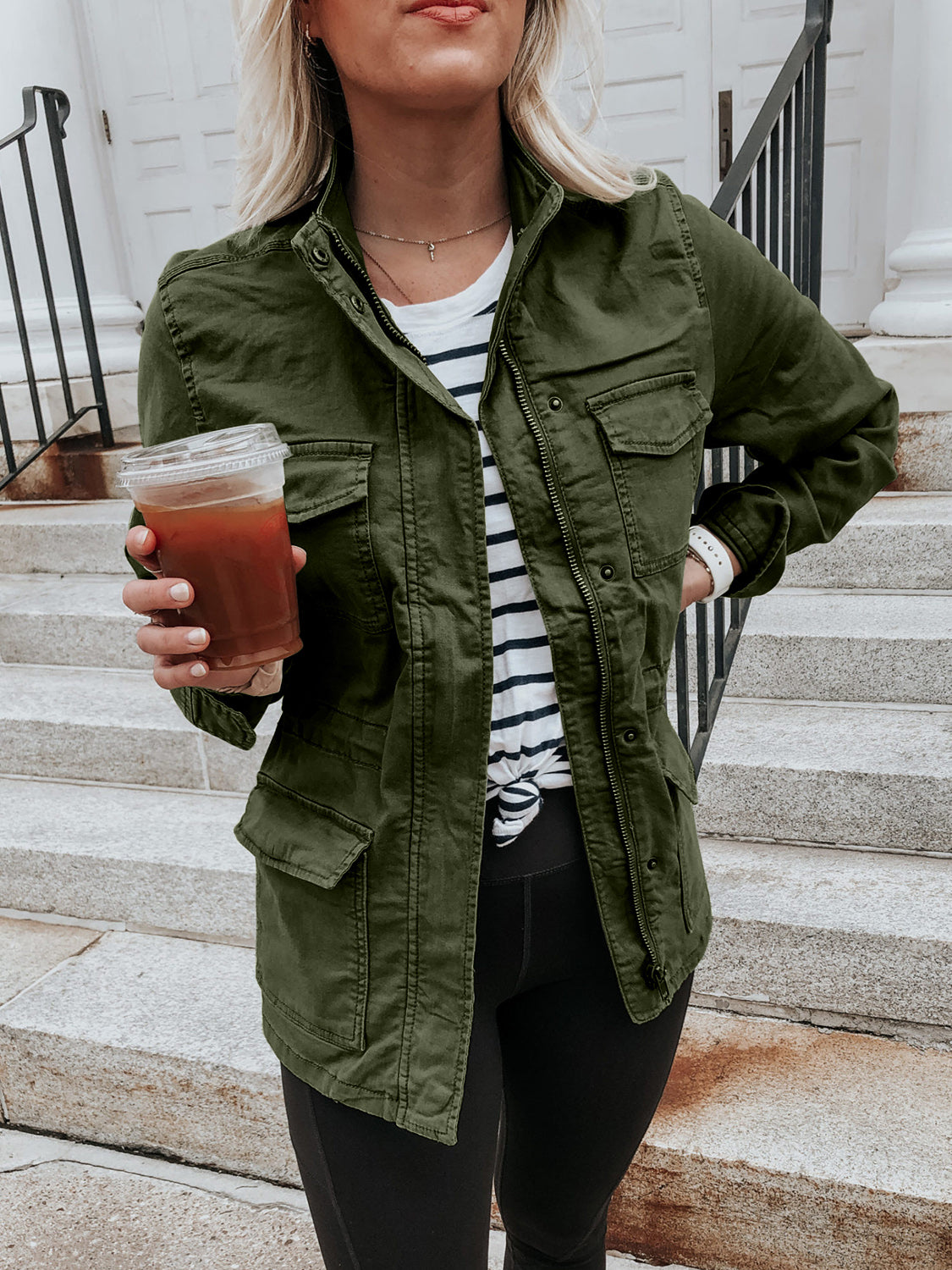 Army green utility jacket with multiple pockets and a zip-up front, styled casually.