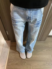 Men's light wash wide-leg jeans with vintage distressing and a relaxed fit.