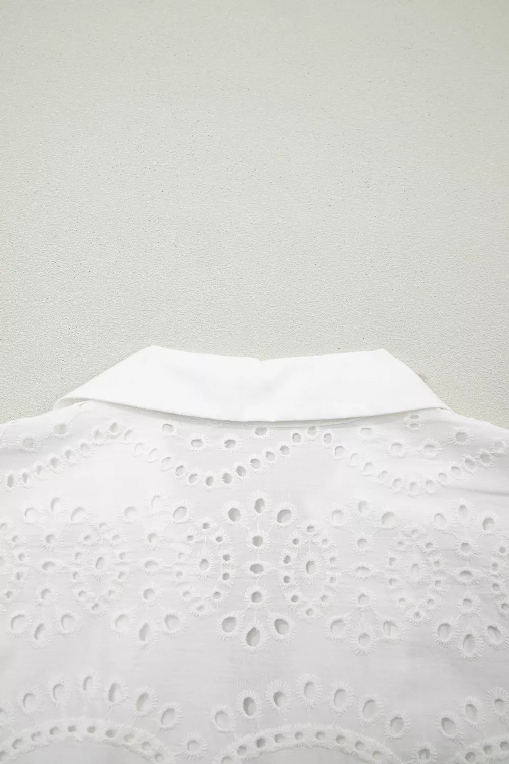 White cotton mini dress with eyelet embroidery and collar detail.