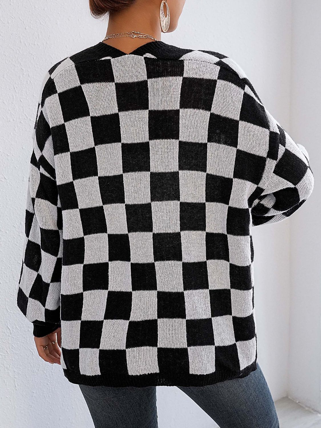 Checkerboard knit cardigan in black and white with balloon sleeves.