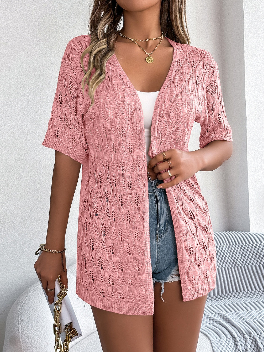 Open-knit leaf motif cardigan in watermelon pink with short sleeves and a V-neck.