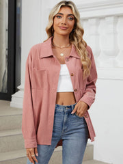 Pink corduroy overshirt with patch pockets and button front, styled with a white crop top and jeans.