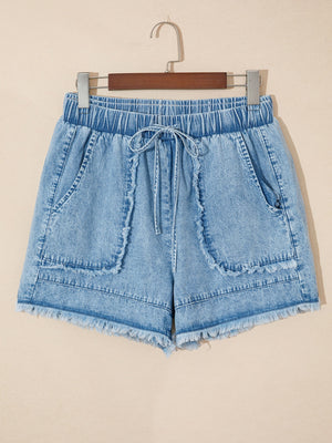 Light wash denim shorts with frayed edges, drawstring waist, and elastic waistband.