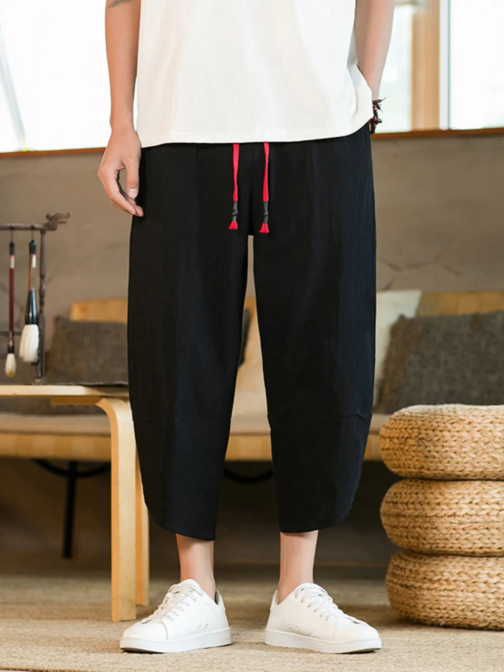 Black drawstring cropped sweatpants for men with red drawstrings.