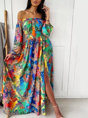 Vibrant off-shoulder maxi dress with balloon sleeves and a high slit, featuring a colorful baroque print.