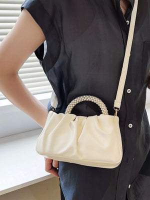 Elegant pearl-handled mini crossbody bag in Rice White with ruched detail and a crossbody strap.