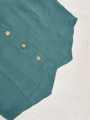 Turquoise cropped vest with wooden buttons and textured fabric detail