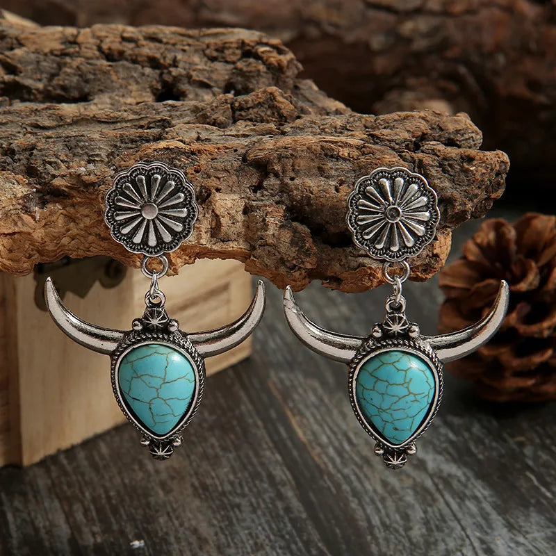 Southwestern crescent drop earrings with turquoise stones and bull horn design in silver alloy.