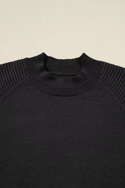 Black acrylic knit sweater with mock neck and ribbed balloon sleeves.