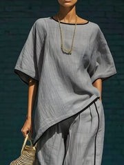 Gray two-piece set with contrast trim, featuring a relaxed top and cropped pants.