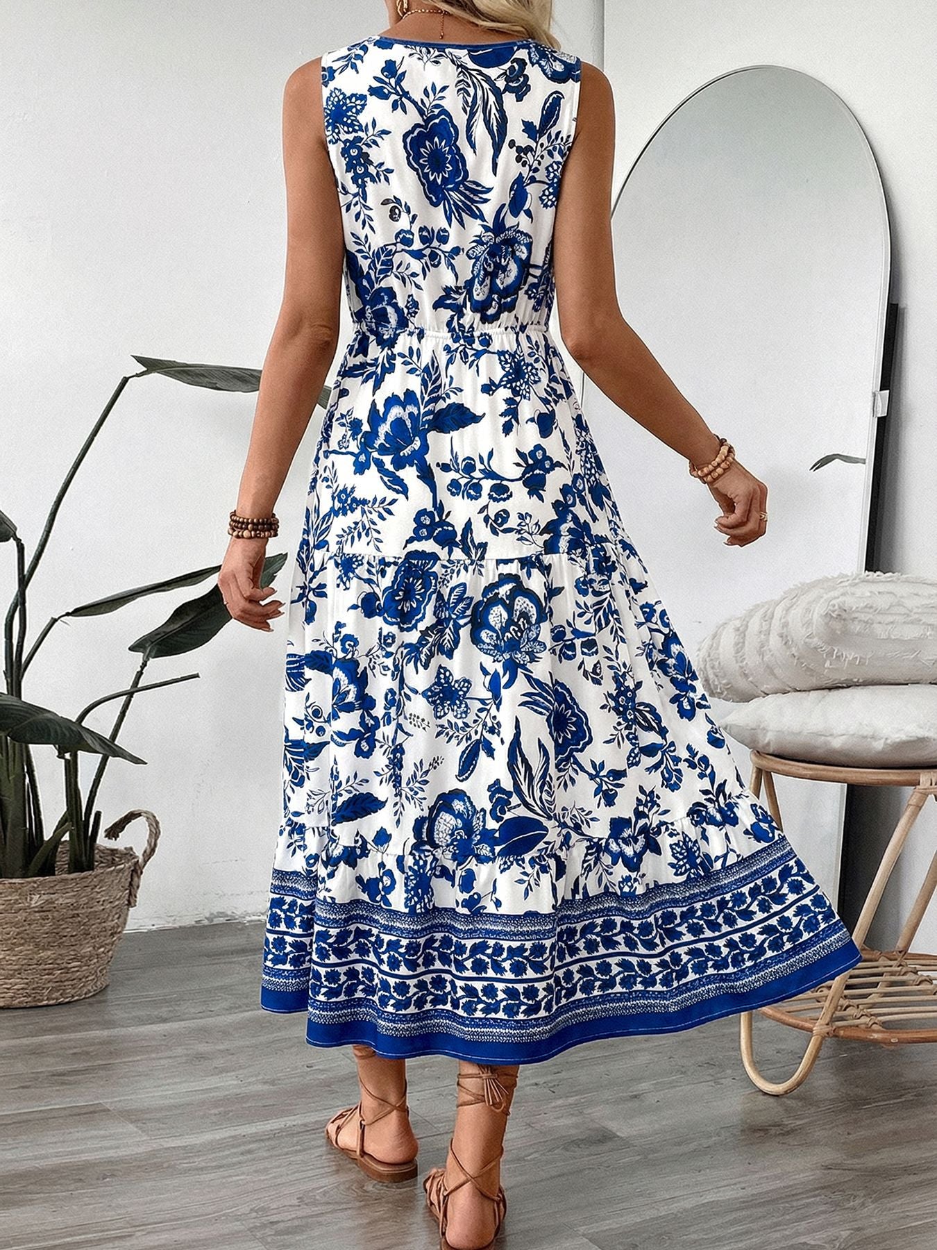 Midi dress with blue floral print, drawstring waist, tiered skirt, and sleeveless V-neck.