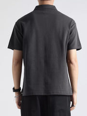 Men's dark gray cotton short-sleeve polo shirt with a zippered neckline detail.