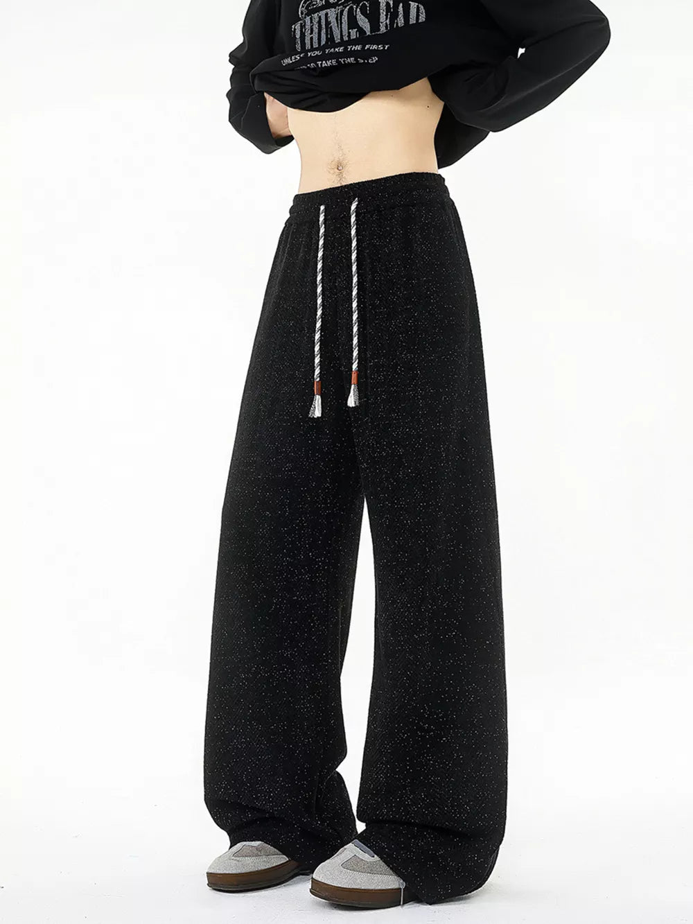 Black textured knit sweatpants with white drawstring and wide leg.