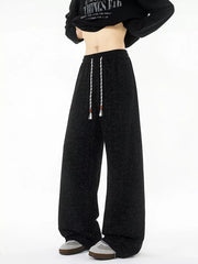 Black textured knit sweatpants with white drawstring and wide leg.