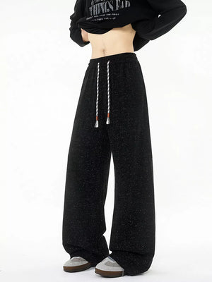 Black textured knit sweatpants with white drawstring and wide leg.
