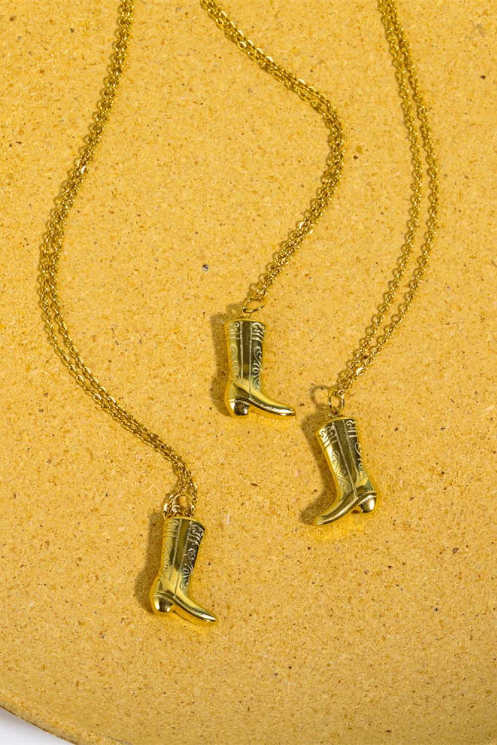 Gold cowboy boot charm necklace with intricate detailing on a delicate chain.