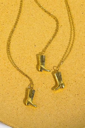Gold cowboy boot charm necklace with intricate detailing on a delicate chain.